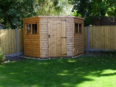 a wooden shed in the middle of a yard