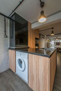 a washer and dryer are in the middle of a kitchen with wooden cabinets