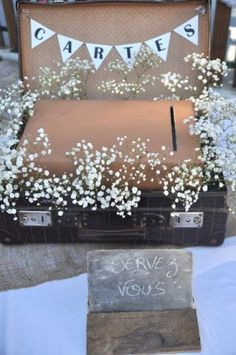 an old suitcase is adorned with baby's breath flowers