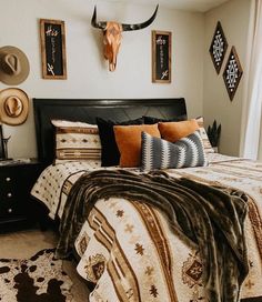 a bed room with a neatly made bed and animal heads on the wall above it