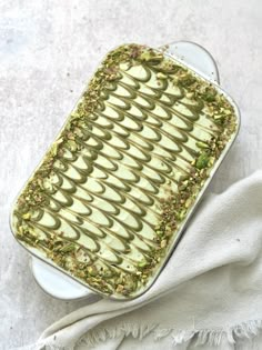 a white plate topped with a cake covered in green frosting