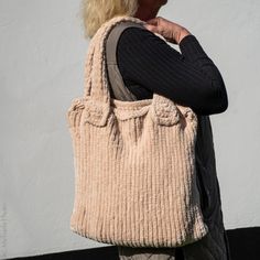 a woman carrying a beige purse on her back