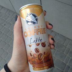 a person holding up a can of coffee