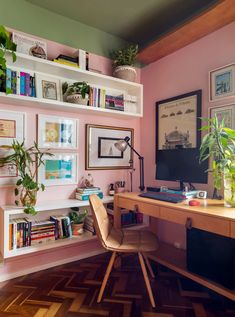 a home office with bookshelves and plants on the wall, along with a desk