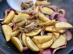 an image of food being cooked in a skillet with onions and other foodstuffs