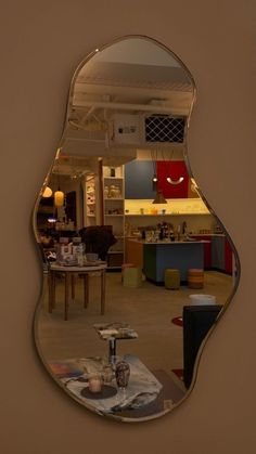 a mirror that is on the wall in front of a dining room table and chairs