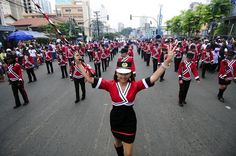 a group of people that are standing in the street with marching equipment on their heads