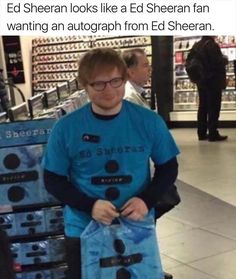 a man in blue shirt standing next to an electronic device with text that reads, ed sheran looks like a ed sheran fan wanting an autograph from ed sheeran