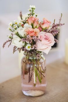 a vase filled with pink and white flowers on top of a table