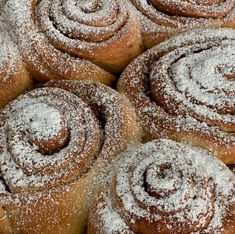 several cinnamon rolls covered in powdered sugar on top of each other and stacked together