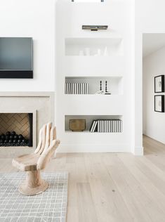 a living room with white walls and wood floors