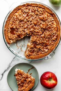 an apple pie with one slice missing from it and another piece on the plate next to it