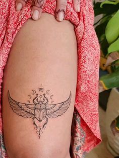 a woman's leg with a tattoo on it and an insect in the middle