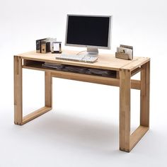 a wooden desk with a computer monitor and keyboard sitting on it's top shelf