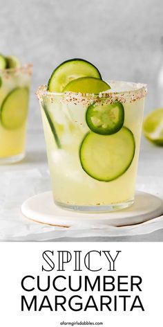 two glasses filled with cucumber margaritas on top of a white plate and the words spicy cucumber margarita