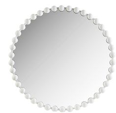 a white circular mirror with beaded edges