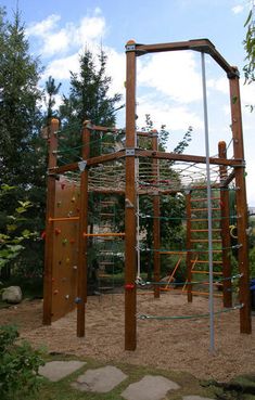 a wooden climbing frame in the middle of a park