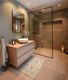 a bathroom with a sink, mirror and shower stall