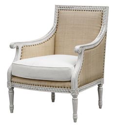 an upholstered chair with white linen and wood trimmings on the legs