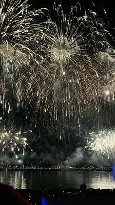 fireworks are lit up in the night sky over water