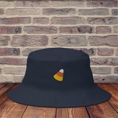 Combine practicality, comfort, and fashion in one. Keep the sun out of your eyes with this 100% cotton twill bucket hat. Cotton fabric and sewn eyelets are sure to help you stay cool during any activity, be it a stroll in the park or an intense game of sports.  * 100% cotton twill * 3 ¾″ (7.6 cm) crown * 2 ¼″ (5.1 cm) brim * One size fits most * Sewn eyelets for breathability Candy Corn Hat, Handmade Halloween Hat, One Size Fits Most, Black Orange Bucket Hat, Novelty Outdoor Bucket Hat, Playful Cotton Bucket Hat, One Size, Denim Hat, Fall Hats, Halloween Hats, Embroidered Hats