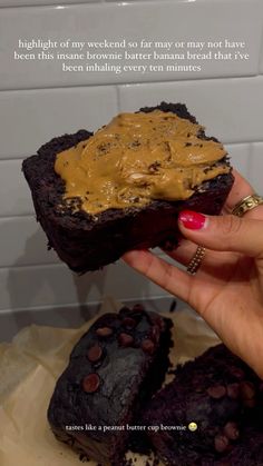 a person holding up a piece of cake with peanut butter on top and chocolate chips on the bottom