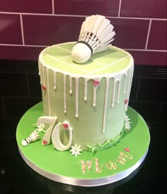 a green cake with white icing and decorations on the top that says 70th