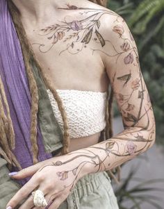 a woman with tattoos on her arms and chest