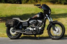 a black motorcycle is parked on the side of the road in front of some grass