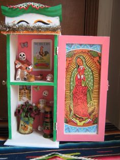 a dollhouse with an image of the virgin mary on it's shelf and other items