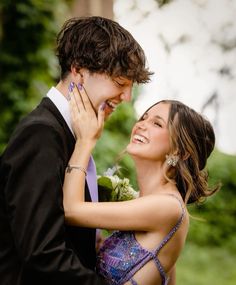 a young man and woman embracing each other