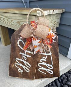 two wooden tags with the words happy fall hanging on a door hanger in front of a house