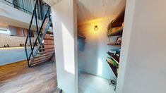 there is a staircase leading up to the second floor in this modern home with wood floors and white walls