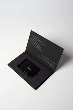 an open black business card holder on a white surface