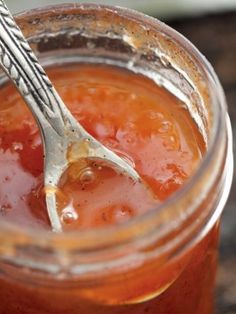 there is a fork and some sauce in the jar