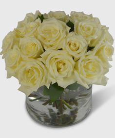 a vase filled with white roses on top of a table