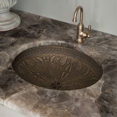 a bathroom sink with an intricate design on the counter top and faucet in front of it