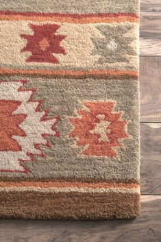 an area rug on the floor with wood floors in the background and wooden planks