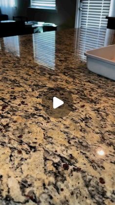 a granite counter top in a kitchen with a window behind it and a video player on the counter