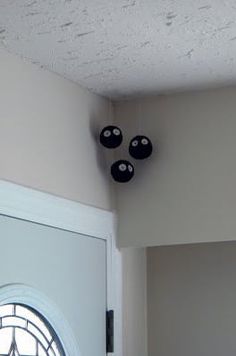 the door is open and there are four black balls hanging on the wall above it