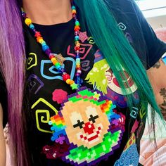 a woman with green hair wearing a black shirt and beaded necklace on her chest