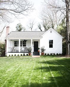 a white house sitting on top of a lush green field