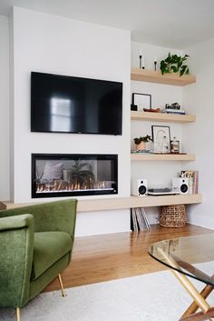 a living room filled with furniture and a flat screen tv mounted on the wall above a fire place