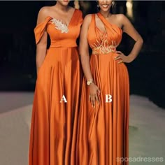 two women in orange dresses standing next to each other with their hands on their hips