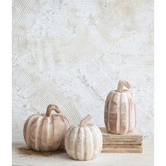 three ceramic pumpkins sitting on top of books