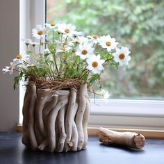 a vase filled with white flowers next to a window