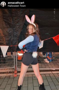 a woman in bunny ears is posing for the camera with her hands on her hips