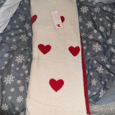 a white blanket with red hearts on it