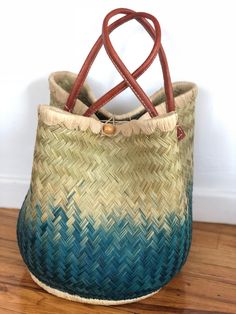 These beautiful pieces are designed in South Africa. Handmade with raffia and featuring leather handles, these bags bring the perfect mix of bohemian chic to everyday wear! Capable of being used as a handbag, basket or storage-this multi-purpose piece is a cannot miss! The double closure top provides a multi-style capability as well! Sizing: 16 inches wide x 12 inches deep x 13 inches high Woven Natural Fiber Basket Bucket Bag, Green Woven Handheld Straw Bag, Green Handheld Woven Straw Bag, Handheld Green Woven Straw Bag, Natural Top Handle Bucket Bag For Market, Top Handle Natural Bucket Bag For Market, Bohemian Palm Leaf Beach Bag For Travel, Bohemian Natural Bucket Bag With Bamboo Handle, Bohemian Bucket Bag With Bamboo Handle In Natural Color