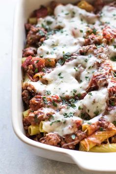 a casserole dish with meat, cheese and sauce in it on a table